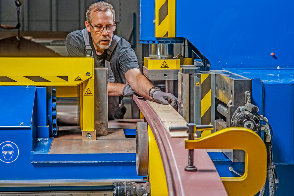 Een medewerker van Romaris Staal bewerkt een stuk metaal