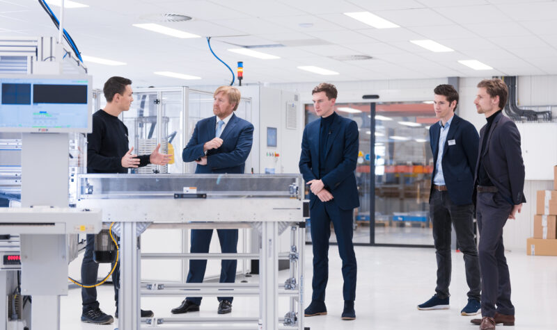 Koning Willem-Alexander krijgt uitleg van een medewerker in de nieuwe batterijfabriek van ELEO