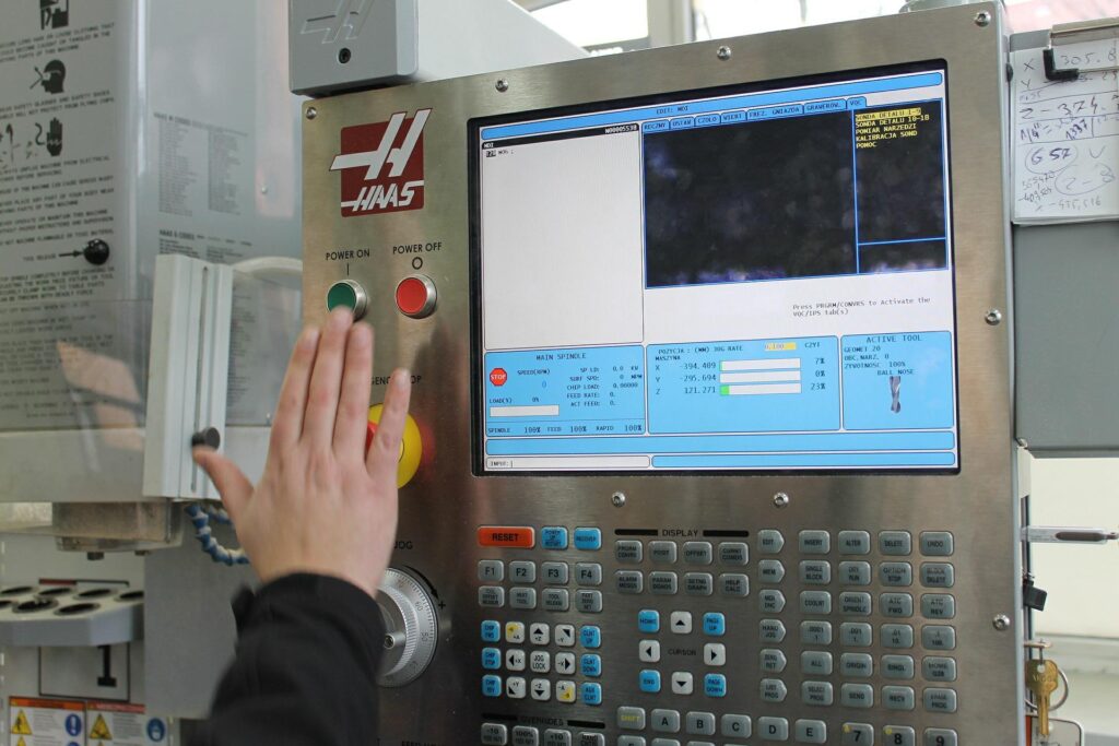 Hand die op een knop druk van een bedieningspaneel in een fabriek